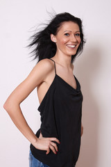 A woman in a black undershirt with tousled hair