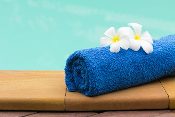 Towel set and flowers beside swimming pool - 53885478