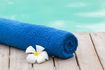 Towel set and flowers beside swimming pool - 53885492