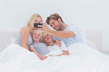 Cheerful family taking self pictures with a smartphone