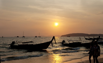 Many anchored boats on the sea with sunset behind