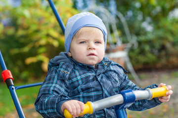 Little toddler boy having fun in autumn park