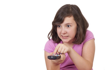 Beautiful teenage girl with tv remote control in her hands