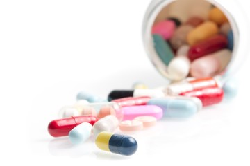 colored pills in laboratory near white container