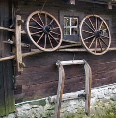 Obraz premium Wagon wheel on old log house