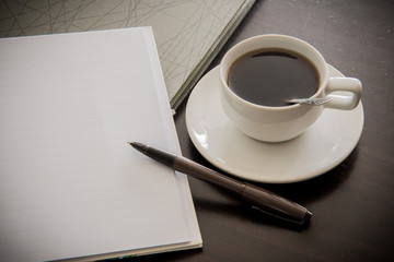 Fototapeta na wymiar Open a blank white notebook, pen and cup of coffee