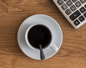 Open a blank white notebook, pen and cup of coffee and Calculato