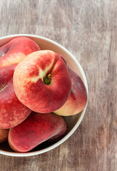 Donut peaches in bowl over wooden background