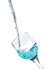 Splash of blue water into the glass