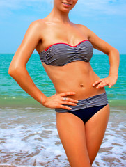 A woman sunbathes on a beach