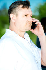 Portrait of middle-aged man with smartphone outdoors