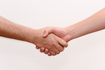 Handshake over the white wall