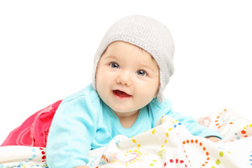 Baby girl with hat lying down and smiling