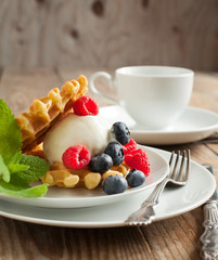 Waffle decorated with ice cream scoop and berries