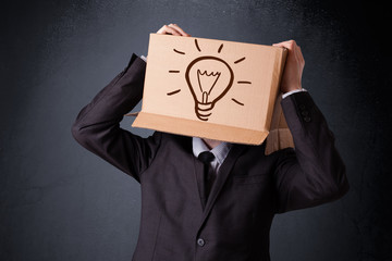 Businessman gesturing with a cardboard box on his head with ligh
