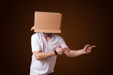 Young man gesturing with a cardboard box on his head