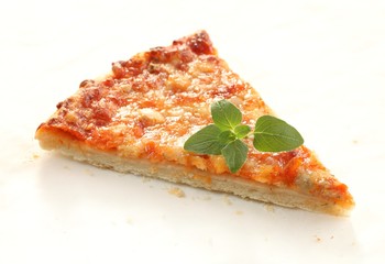 Pizza with cheese and fresh oregano on paper background.