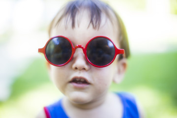 The cute boy with red sunglasses shallow depth of field