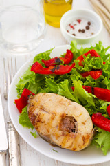 fish with salad on plate and olive oil