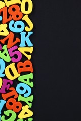 colorful numbers and letters on black background with copy space