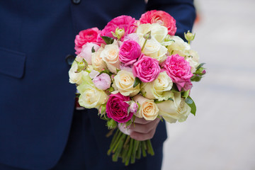 A young groom holding bouquet of flowers