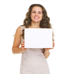 Naklejka premium Portrait of happy young woman showing blank paper