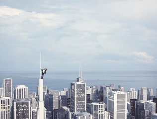 man on the top of skyscraper looking at the city