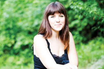 Obraz premium Portrait of young woman standing against a nature background