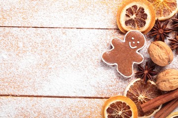 Gingerbread cookie and spices on sugar background.