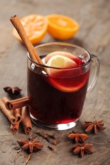 Mulled wine and spices on wooden background.