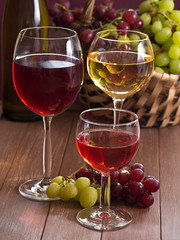 Wein im Weinglas mit einem Korb Weintrauben im Hintergrund