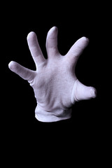 Hand in white glove making sign isolated on black