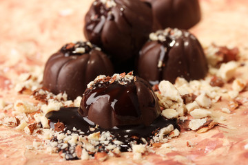 Chocolate candies with nuts, on color background