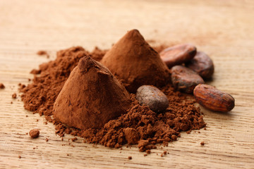 Chocolate truffles and cocoa, on wooden background