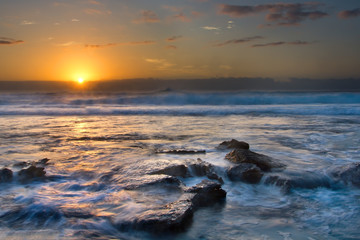 Naklejka premium Sunrise landscape of ocean with waves clouds and rocks