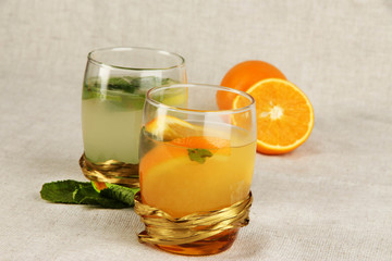 Lemonade in glasses on fabric background close-up