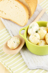 Tender young potatoes with sour cream and herbs in pan