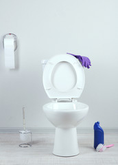 White toilet bowl and  cleaner bottle in a bathroom