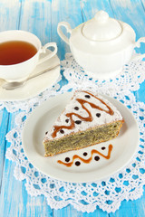 Delicious poppy seed cake with cup of tea on table close-up
