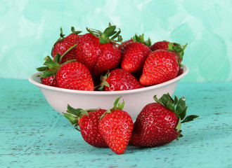 Strawberries in plate on blue background