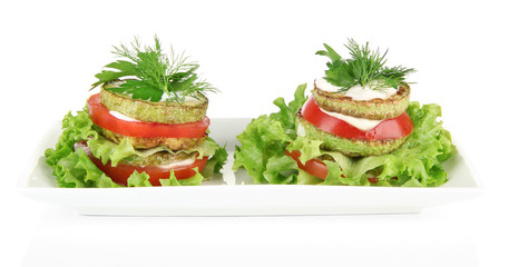 Tasty roasted marrow and tomato slices with salad leaves,