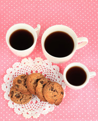 Cups of coffee with cookies on pink napkin