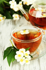 Cup of tea with jasmine, on wooden table, close-up