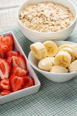 Oat flakes in bowl with banana and strawberry