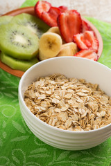 Oat flakes in bowl with banana and strawberry