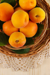 Apricots on wicker coasters on napkin on  wooden table