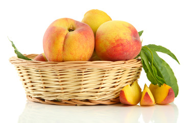 Naklejka na ściany i meble Ripe sweet peaches with leaves in basket, isolated on white
