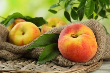 Ripe sweet peaches on wooden table in garden, close up
