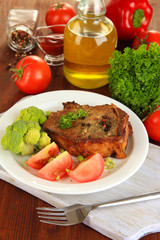 Piece of fried meat on plate on wooden table close-up