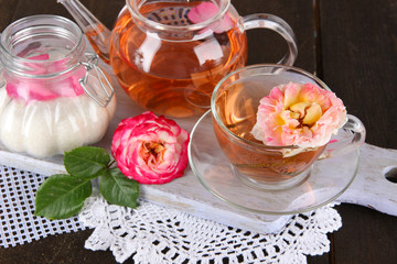 Fototapeta na wymiar Kettle and cup of tea from tea rose